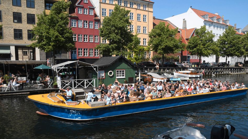 Copenhagen, Denmark. 24 July 2021,People snejoy summer weather with oat crusing tourism in Christianshavn canal on Amage