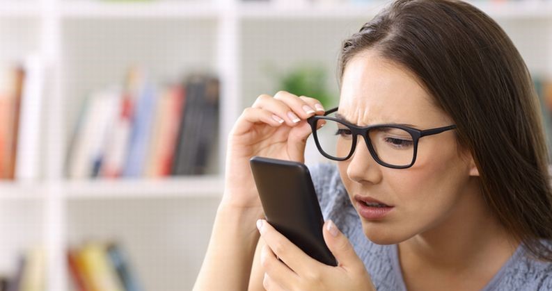 Girl with eyesight problems trying to read phone text